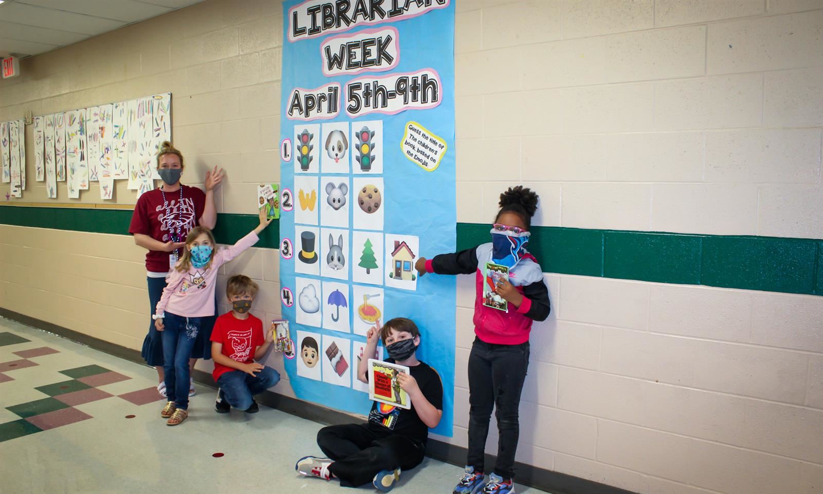 Students stand outside a National Library Week chart 